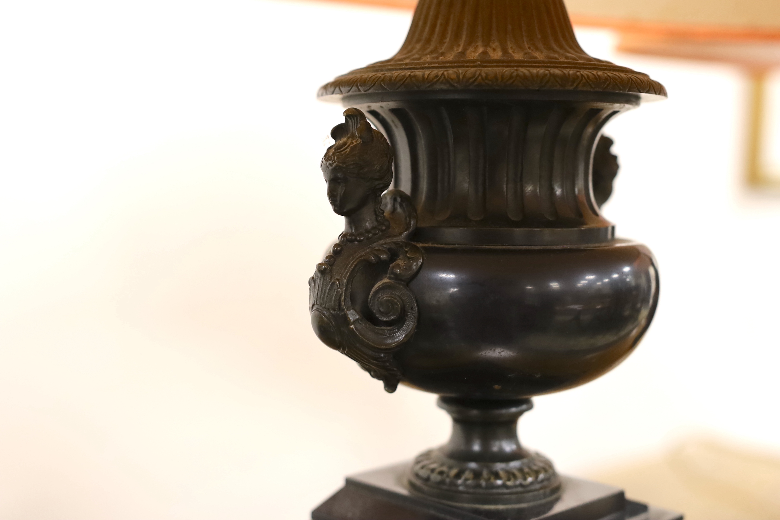 A pair of bronze and polished slate urns, converted to desk lamps (likely ex clock garniture), 34cm high excluding the fitting